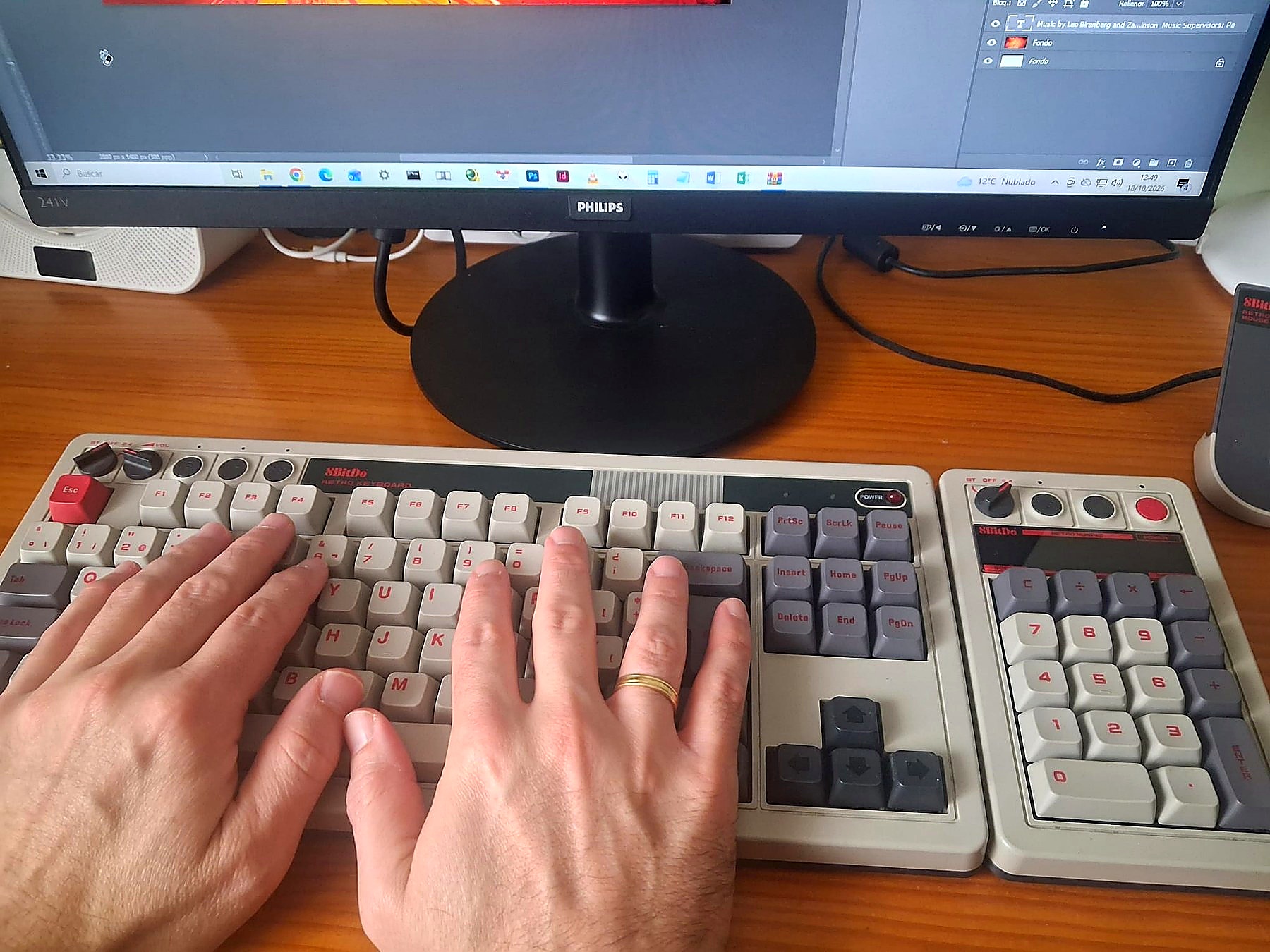 Manos trabajando en el teclado frente al ordenador, con un diseño abierto en pantalla